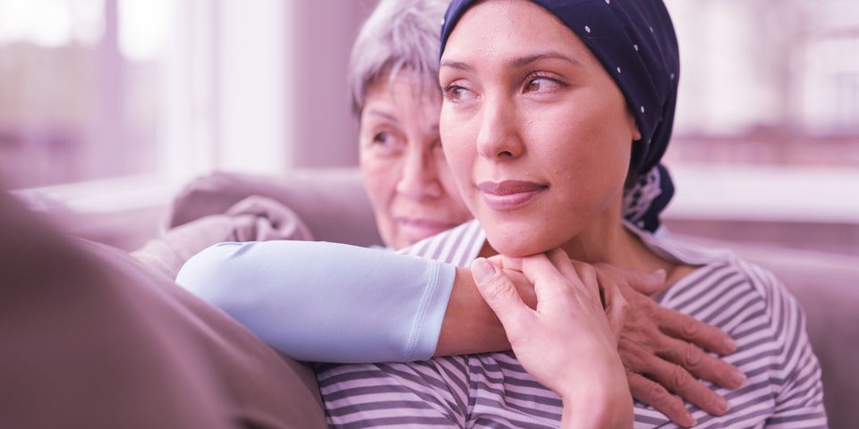 Two women on a couch, one is a cancer survivor.