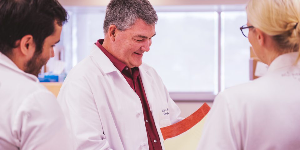 Three researchers in a lab reviewing test results.